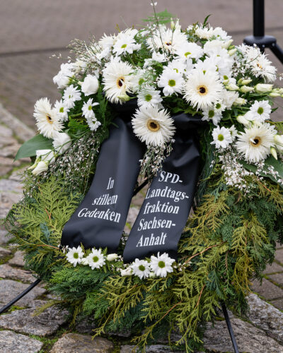 Das Bild zeigt einen Trauerkranz mit weißen Blumen und einer schwarzen Schleife mit weißer Aufschrift "In stillem Gedenken - SPD-Landtagsfraktion Sachsen-Anhalt"